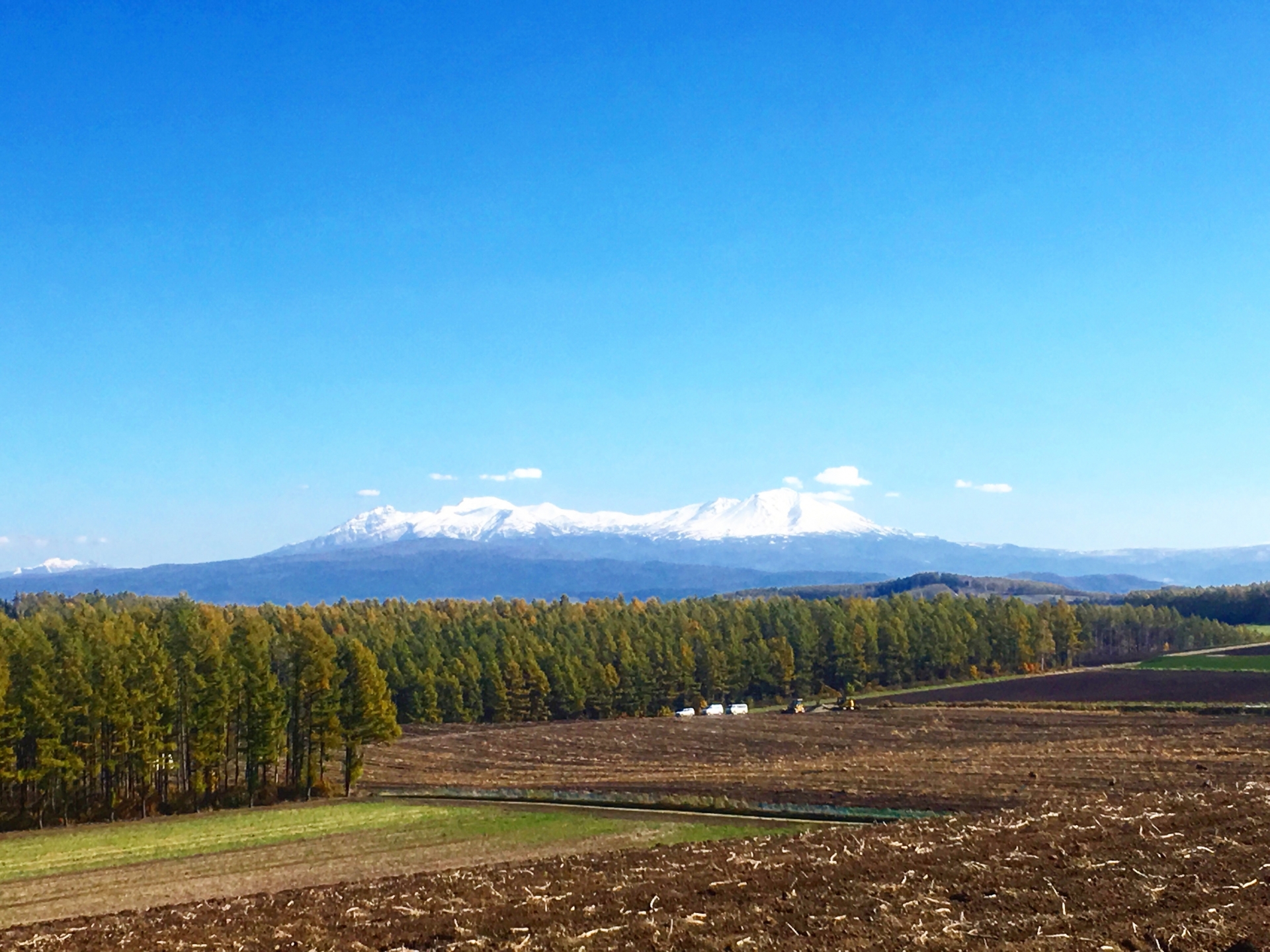 雄大な山並みが連なる大雪山連峰と十勝岳連峰を眺めながらライディング